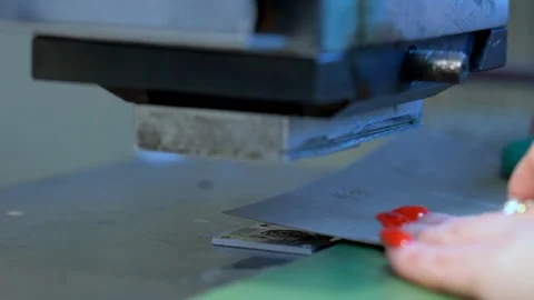 The woman in the workshop use press machine to get the embossed details Stock Footage 120899341
