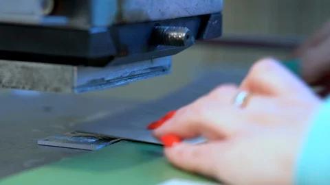 The woman in the workshop use press machine to get the embossed details Stock Footage 120899600