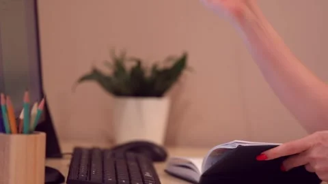 A woman writes in a diary with a pencil on the desktop. Stock Footage