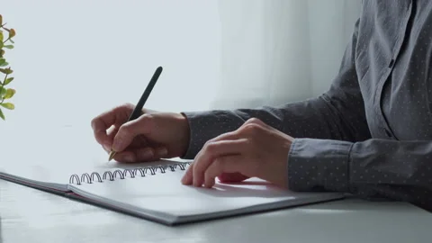 A woman writes down ideas and notes in a notebook. Planning the day  Stock Footage 163962962
