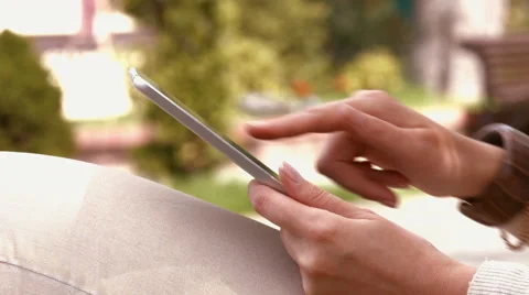 Woman writes a message on tablet in the park Stock Footage 50215544