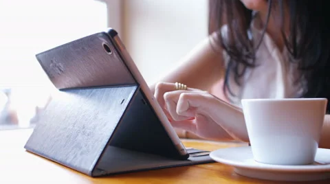 Woman writes a message on tablet pc in the cafe Stock Footage 50226073