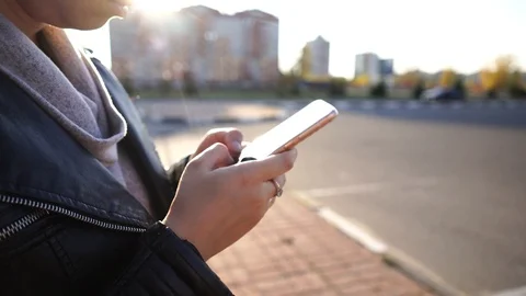 A woman writes a message using a smartphone while standing Stock Footage 118315110