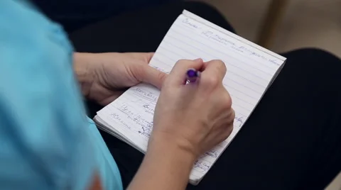 A woman writes in a notebook Stock Footage 67353956