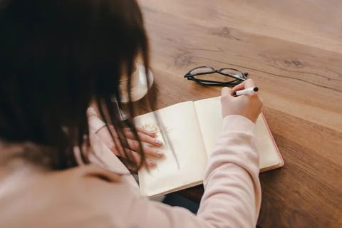 Woman writes notes in notebook or diary Stock Photos