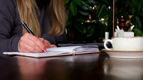 A woman writes a plan in a notebook. Planning, online education, manager, Stock-Footage 175787774