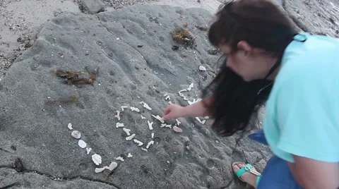 Woman writes the word love stones on the beach Stock Footage 59195896