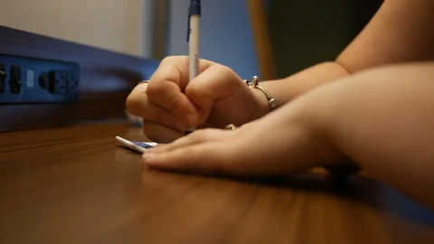 Woman writing dramatic note on desk Stock Footage