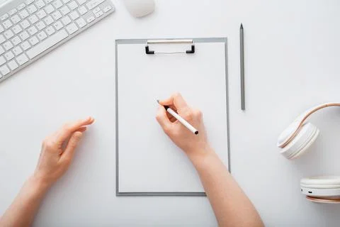 Woman writing on empty list in notepad to do list. Female hands do sketching on Stock Photos