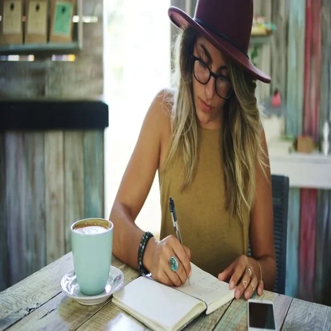 Woman writing in journal in cafe Stock Footage