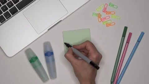 Woman writing KNOWLEDGE on notepad, close up. Laptop and stationery on the desk Stock-Footage 101959403