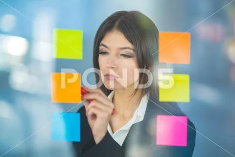 The woman writing a note on the sticker Stock Photos