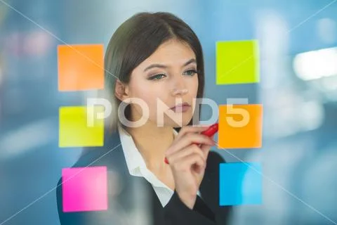 The woman writing a note on the sticker Stock Photos