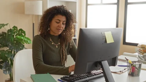 Woman writing in notebook at desk with computer monitor and keyboard, pen i.. Stock Footage 339180468