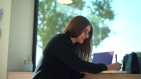 Woman writing in notebook during remote work Video stock 165026064