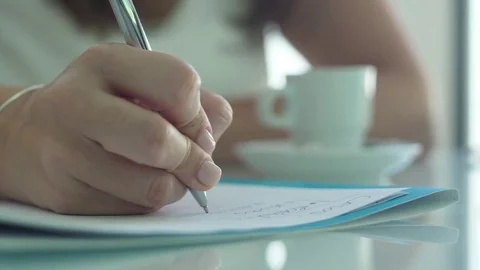 Woman writing in a notebook with a pen slow motion Stock Footage