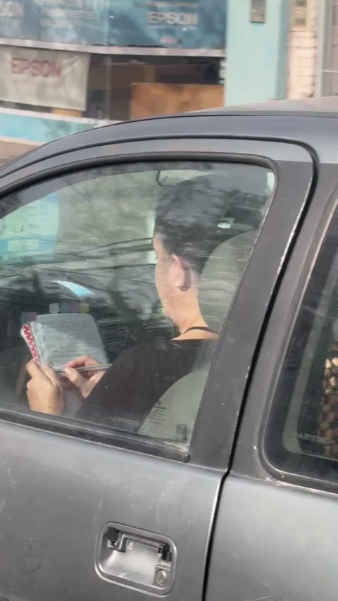 Woman Writing in a Notebook While Driving, Neuquen, Argentina - 13 May 2026 Stock Footage 337974391