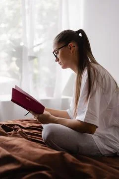 Woman writing notes in notebook while sitting Stock Photos