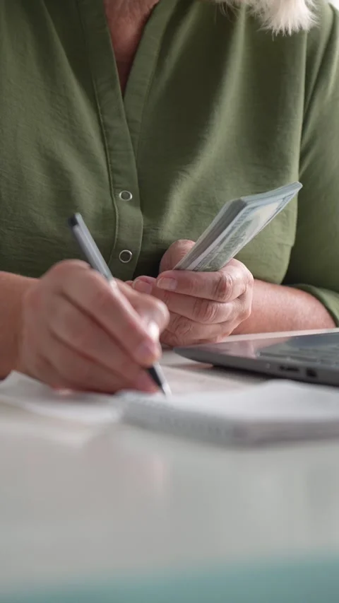 Woman writing notes on notepad at workplace and count money Stock Footage 316551217