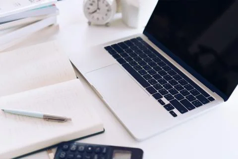 Woman is writing in planner notebook while using laptop to work or plan wit.. Stock Photos