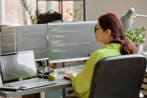 Woman Writing Script on Multiple Computer Screens Stock Photos