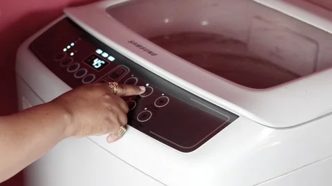 Woman&amp;#039;s hand sets the washing program in the washing machine Video stock 308943815