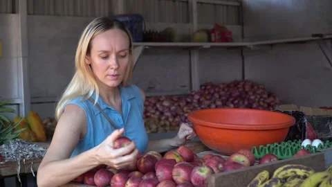 The Woman's Apple Quest: A Nutritious Choice at the Fruit Market Stock-Footage 242774412