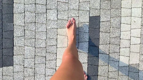 Woman's bare feet are taking steps on grey stone blocks.. Stock Footage 115599786