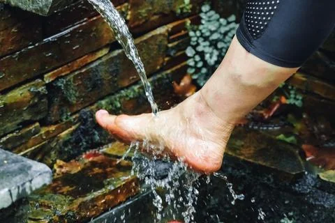 A woman's bare feet in a refreshing stream of natural water: getting outdoors Stock Photos
