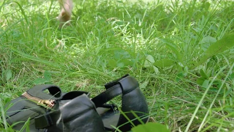 Woman's bare feet walking over green grass field, Flowers of clover. Close-up. Stock Footage 80273792