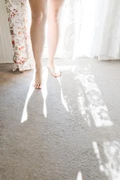 Woman's barefoot in window light - shadow of legs - sunny light Фото