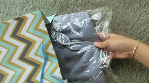 A woman's blouse wrapped in plastic was taken out of the parcel bag. Stock Footage 276418278