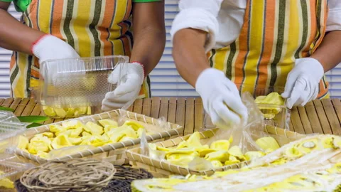 The womans clean and put the jackfruit in a plastic container on wooden table Stock Footage 90781287