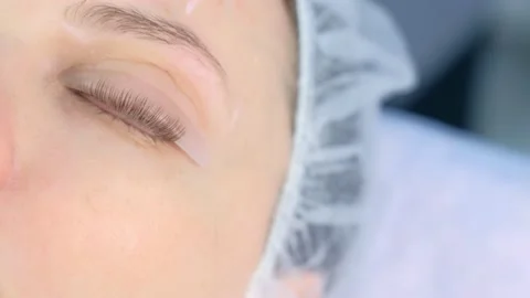 Woman's closed eye with bending lashes on curlers, lift eyelashes laminaton. Stock Footage 136873981