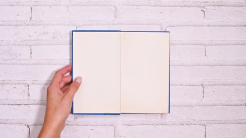 Woman's Creative Page Turn of blue book on brick background Video stock 254813860