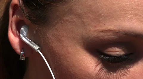 Womans eye and ear with white headphones Vídeo Stock 40056357