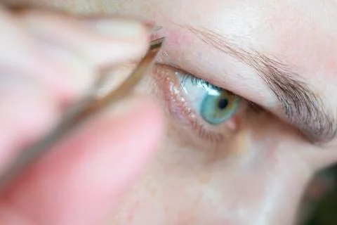 A woman's face in close up doing an eyebrow correction Stock Photos