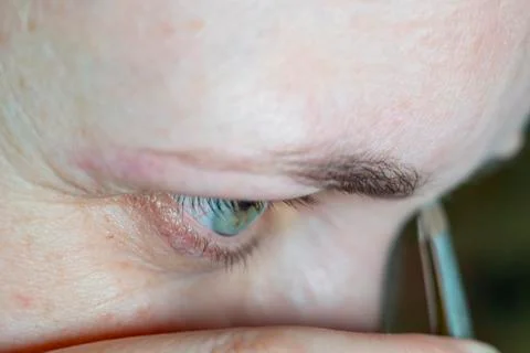 A woman's face in close up doing an eyebrow correction Stock Photos