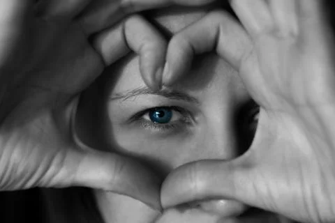 The woman's face close up looking through hands 写真素材