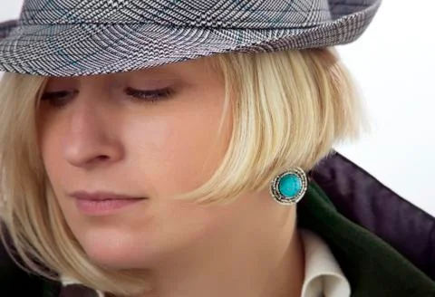 Woman's face with a cyan earring Stock Photos