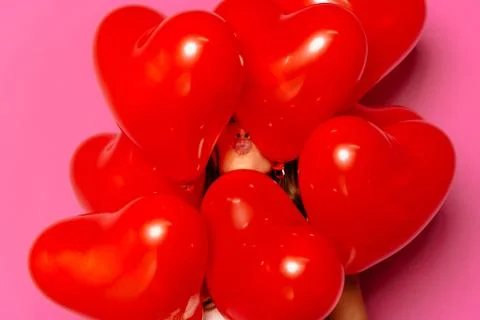 Woman's face hiding between red balloons Stock Photos