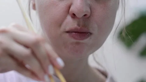 Womans face as she eats udon noodles with chicken Stockbeeldmateriaal 346781646