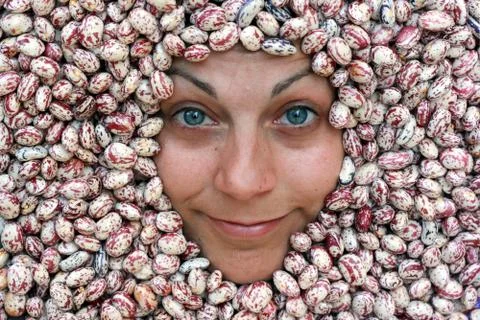 Woman's face surrounded by beans Stock Photos