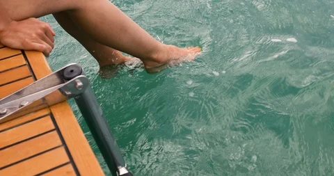 Woman's Feet In Ocean Water While Sitting On The Back Of A Boat Stock Footage 104452807