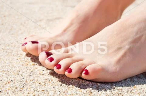 Womans feet on sand Stock Photos