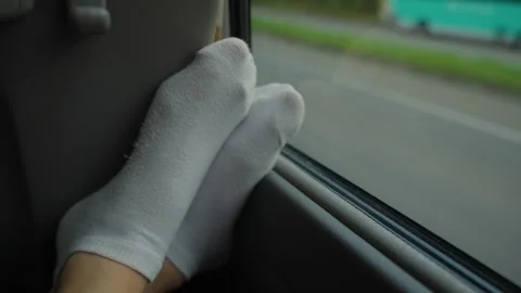 Woman's feet in socks resting during road trip by bus or car Stock Footage 340667812