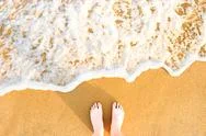 Woman's Feet On Yellow Beach Sand Stock Photos