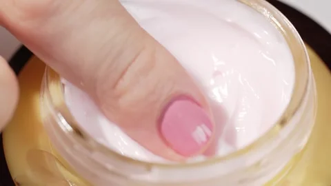 Womans finger gently scoops thick face cream from a clear jar. Close-up vie.. Stock Footage 315032821