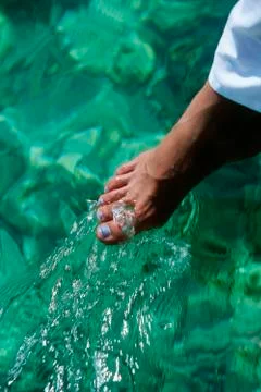 Woman's foot outdoors dipping into water (selective focus) Stock Photos