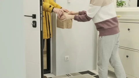 A woman's hand accepts the delivery of eco packages from a delivery man Stock Footage 168082302